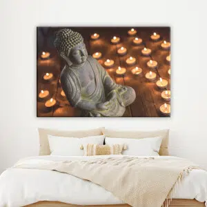 Tableau Bouddha assis devant une bougie. Bonne qualité, original, accrochée sur un mur au dessus d'un lit dans une maison