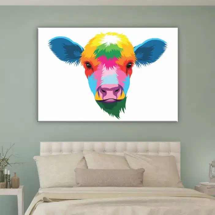 Tableau tête de vache multicolore. Bonne qualité, original, accroché sur un mur au-dessus d'un lit dans une maison