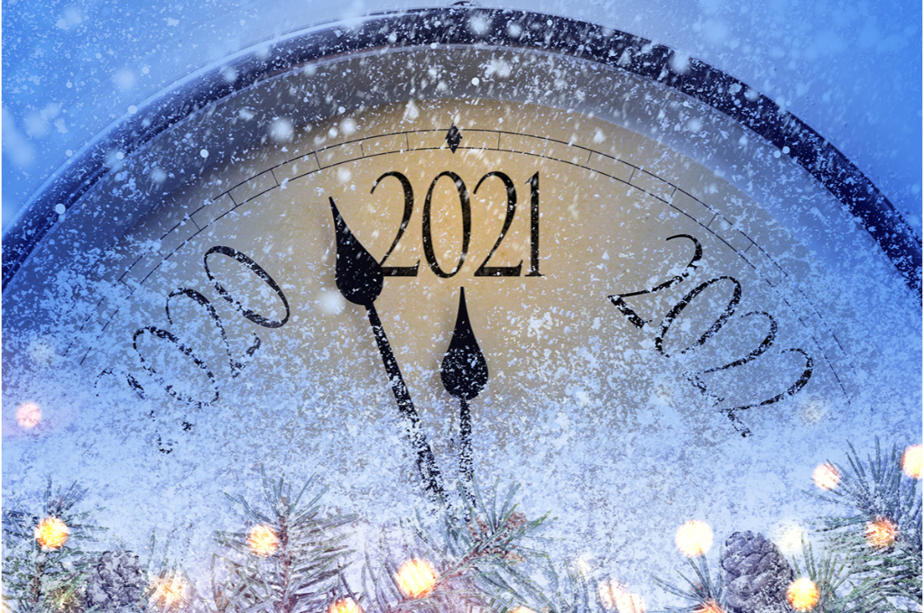 vue sur une horloge coupée remplie de neige, sur laquelle il est écrit à la place des heures, les années. L'aiguille arrive presque à l'année 2021.