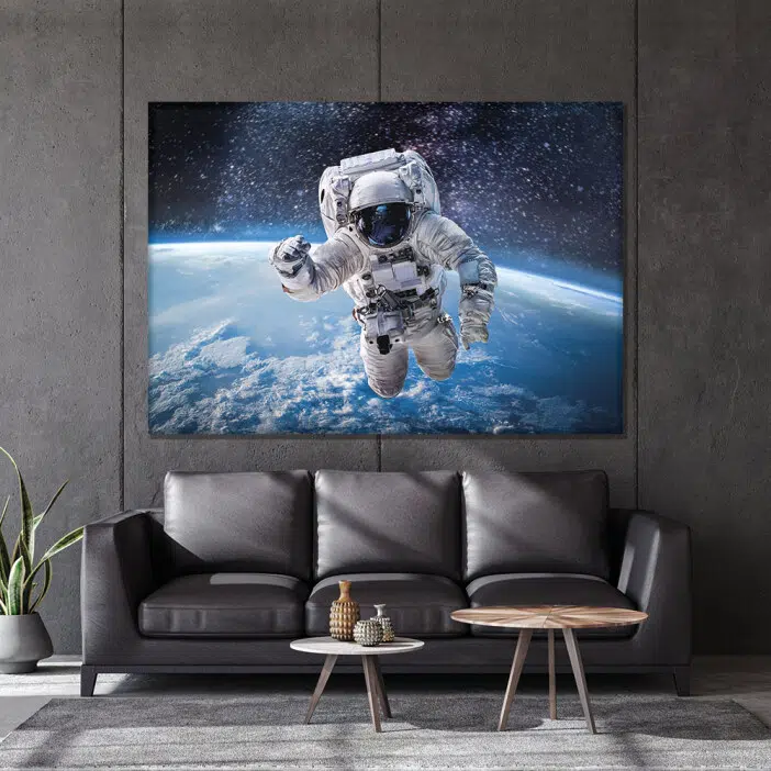 Tableau espace astronaute terre. Bonne qualité, original, accrochée sur un mur au dessus d'un canapé dans un salon