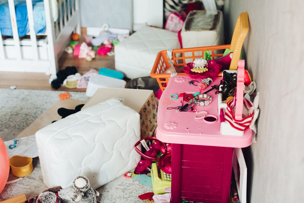 vue fragmentée d'une chambre d'enfant en désordre total avec des tas de jouets qui jonchent le sol.