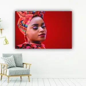 Tableau africain femme sous fond rouge. Bonne qualité, original, accrochée sur un mur au-dessus d'une chaise dans une maison