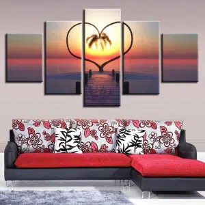 Tableau Jungle en 5 parties cœur de palmiers au soleil couchant installé au dessus d'un canapé imprimé rouge et blanc