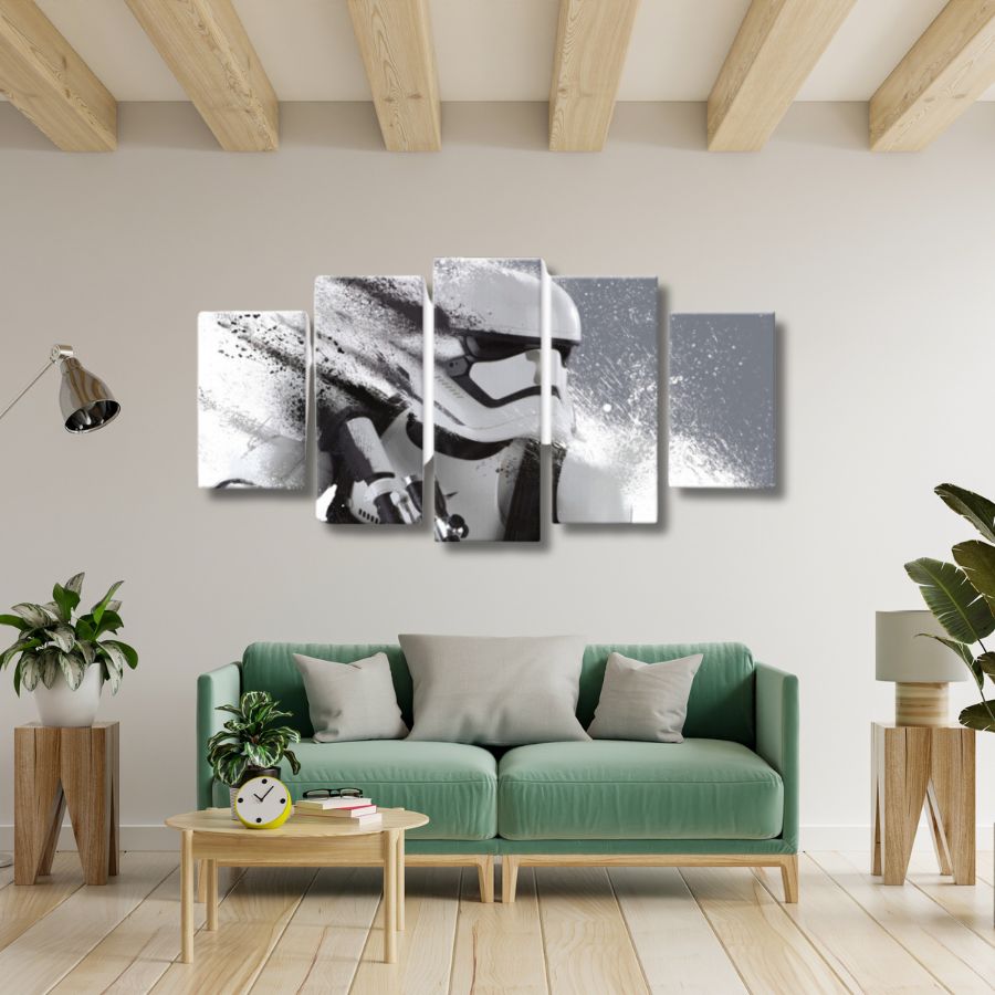 présenté sur fond blanc, un tableau en 5 pièces représentant la tête d'un stormtrooper de Star Wars sur un mur gris avec un canapé dessous.