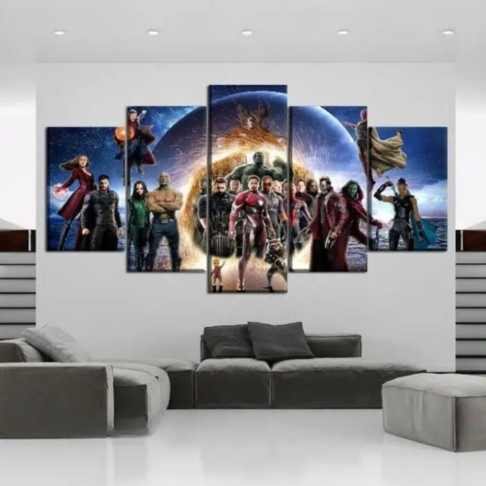 dans un salon, installé sur un mur au dessus du canapé, un tableau en 5 pièce des héros marvel alignés et prêts à combattre