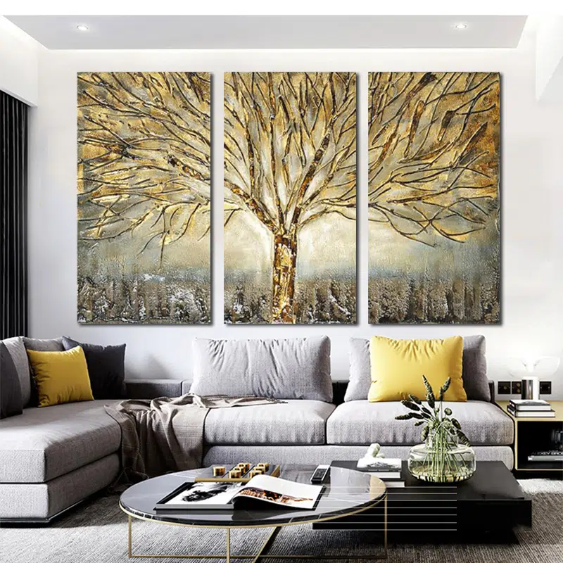 Tableau triptyque nature avec arbre doré installé dans un salon au dessus d'un canapé