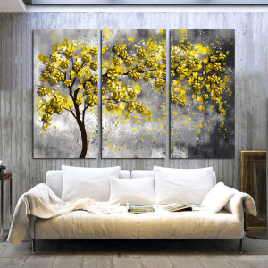 Tableau triptyque nature avec arbre jaune installé au dessus d'un canapé dans un salon