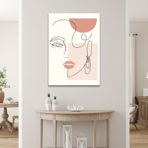 Tableau visage abstrait minimaliste accroché au mur d'un séjour au-dessus d'une console en demi-cercle avec éléments de décoration comme des vases et des lanternes