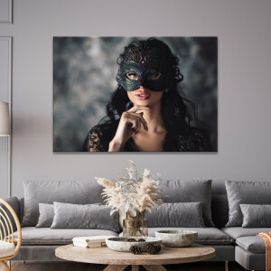 Tableau visage de femme masquée de noir accroché au mur gris d'un salon de style classique avec grand canapé gris et table basse en bois sur laquelle sont posées des décorations