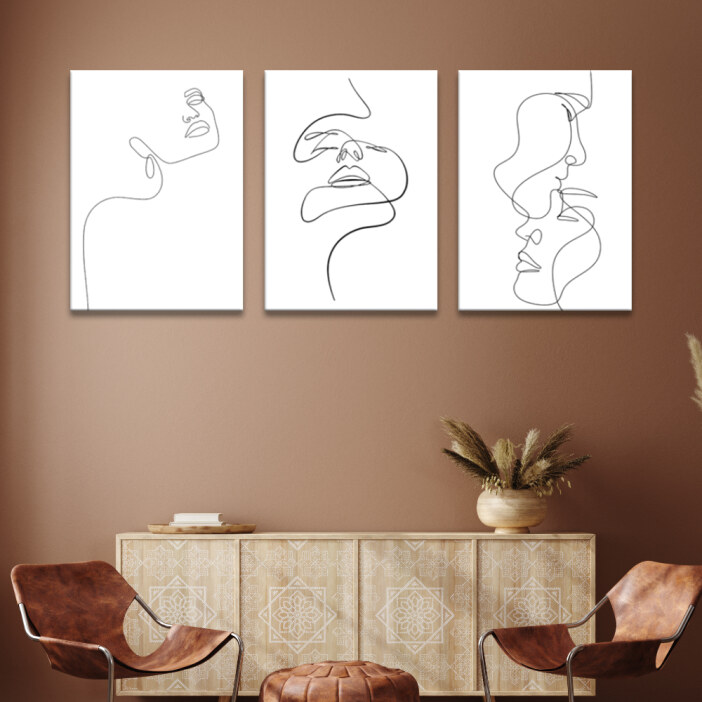 Tableau visage minimaliste noir sur blanc accroché sur le mur ocre d'un séjour avec buffet en bois décoré et fauteuils en cuir marron
