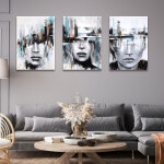 Tableau visage art contemporain accroché dans un salon au style classique aux murs gris au-dessus d'un canapé gris encadrant une table basse en bois décorée