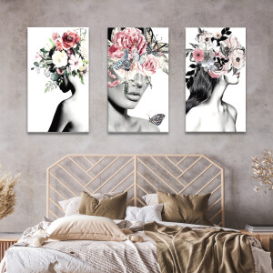 Tableau visage couvert de fleurs sur fond blanc accroché au mur beige d'une chambre au-dessus d'une tête de lit façon rotin