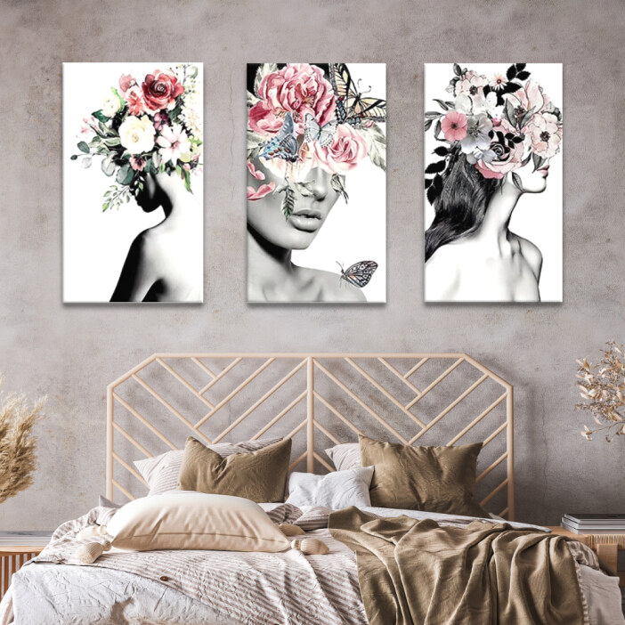 Tableau visage couvert de fleurs sur fond blanc accroché au mur beige d'une chambre au-dessus d'une tête de lit façon rotin