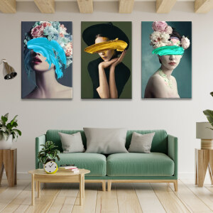 Tableau visage femme aux yeux couverts de peinture affiché dans un salon au-dessus d'un canapé vert tendre avec table basse en bois, parquet et poutres de bois clair au plafond