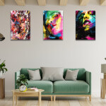 Tableau visage graffiti de femme multicolore accroché dans un salon avec poutres au plafond et canapé vert tendre en bois clair assorti à une table basse