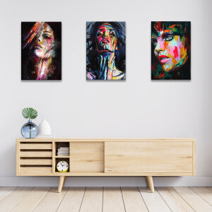 Tableau visage graffiti de femme sur fond sombre accroché dans un séjour ua-dessus d'un buffet bas moderne en bois clair avec portes coulissantes