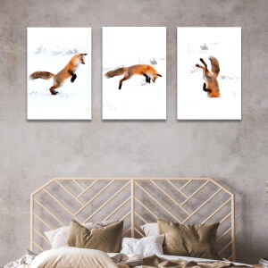 Tableau renard rigolo qui saute dans la neige accroché au mur beige d'une chambre au-dessus d'une tête de lit en rotin