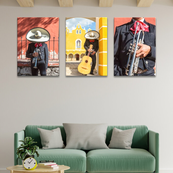 Tableau Mexique mariachis prenant la pose affiché dans un salon avec poutres de bois clair au plafond au-dessus d'un canapé vert doux avec coussins gris et petite table basse en bois