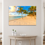 Tableau Mexique plage de palmiers de la Riviera Maya accroché dans un séjour sur un mur beige au-dessus d'une console en demi-lune en bois clair avec des vases posés dessus.