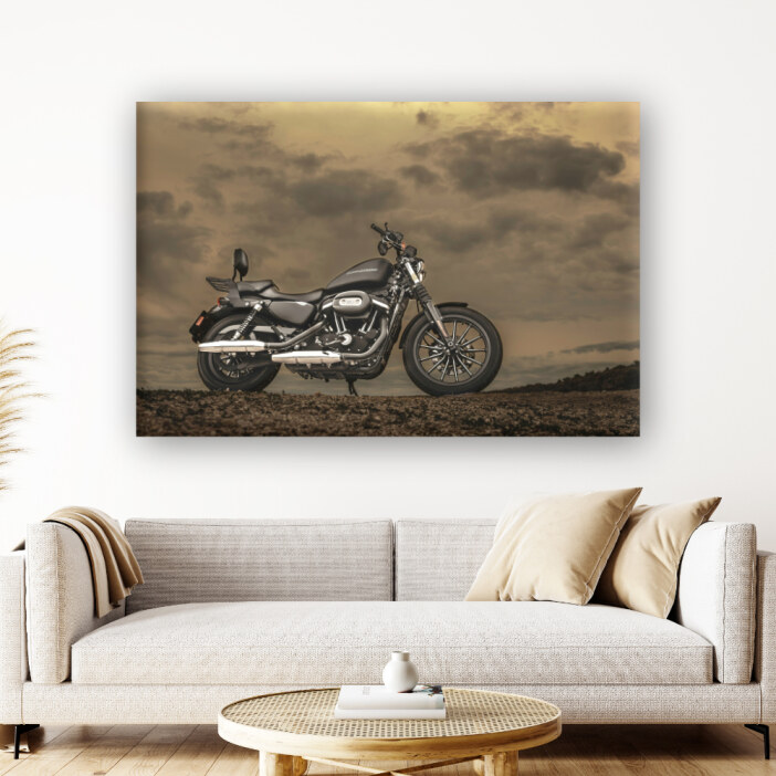 IMG_tableau_moto_paysage_orageux_01 Un tableau de moto Harley Davidson dans un paysage orageux accroché au-dessus d'un canapé beige.